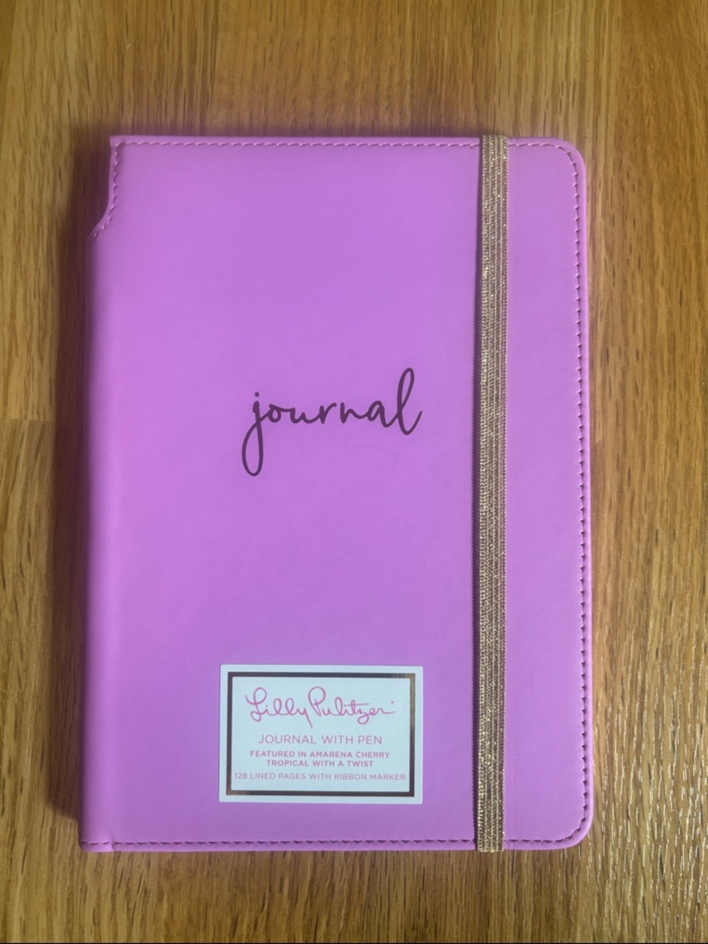 Lilly Pulitzer Pink Hardcover Journal Gold Elastic. 
Does not include pen.
